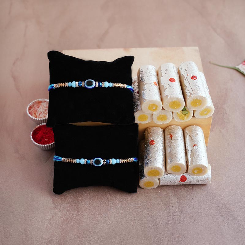 Send Two Evil Eye Rakhis With Kaju Roll Sweets Online Rakhibazaar