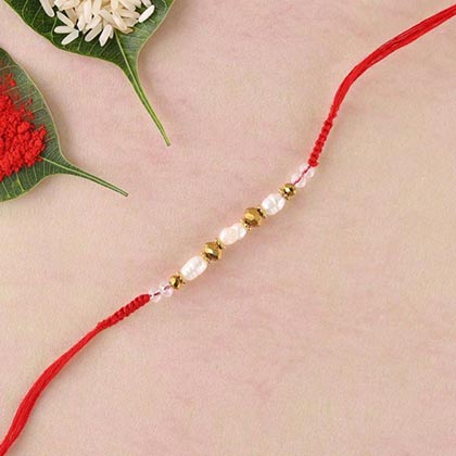 Freshwater pearls,brass beads and crystal in red flat woven rakhi thread