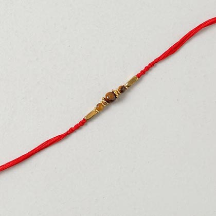 Tiger eye stone and brass bead rakhi in spiral woven red cotton thread