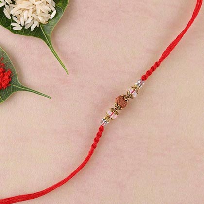 Rudraksha and crystal rakhi with brass beads and red spiral woven thread