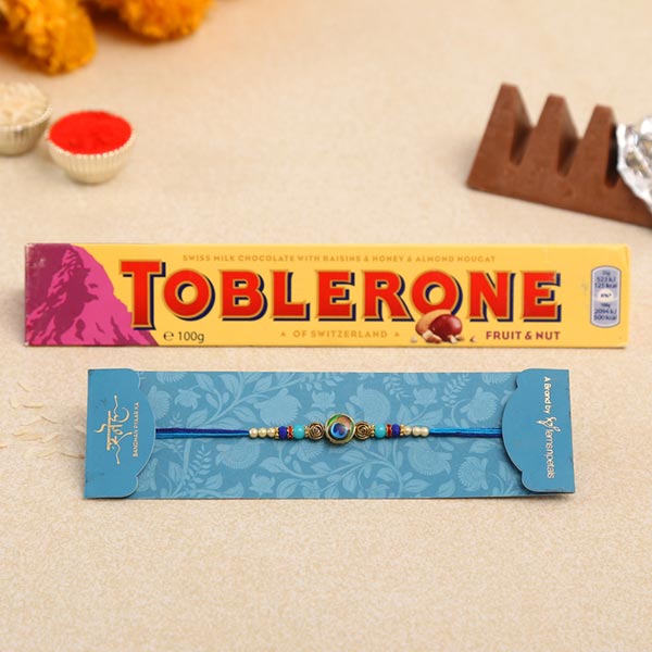 Circular Peacock Feather Rakhi And Toblerone Chocolate