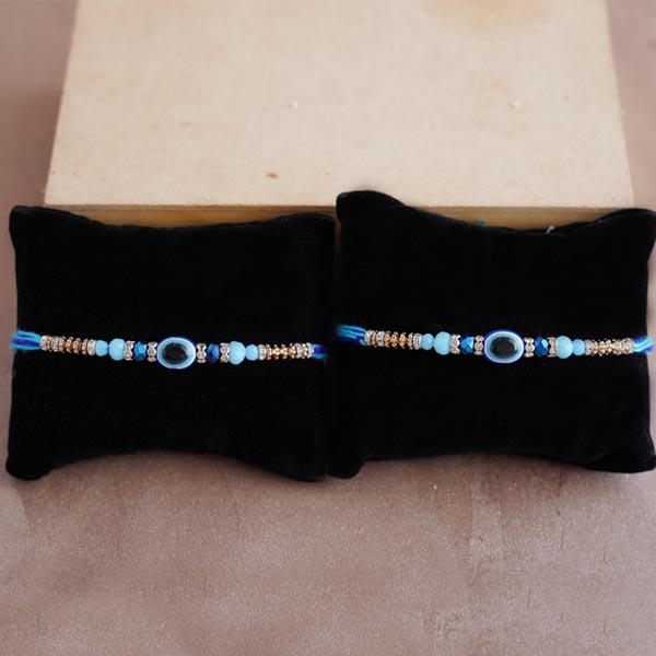 Two Evil Eye Rakhis with kaju Roll Sweets