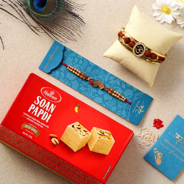 Om Bracelet & Red Peacock Rakhis With Soan Papdi